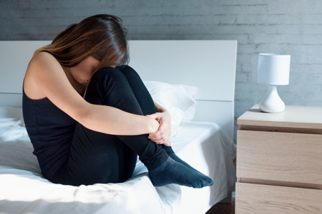sad woman sitting on bed