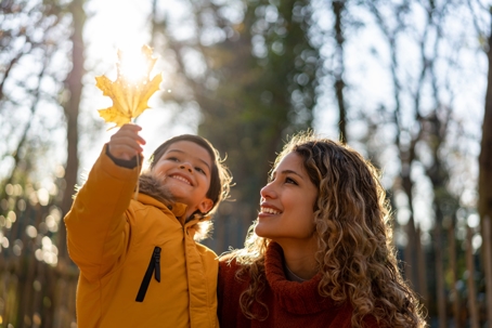 mother and child playing outside during fall