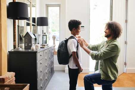 father helping son get ready for school