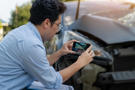 person taking photo of car accident scene
