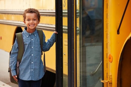 boy getting on school bus